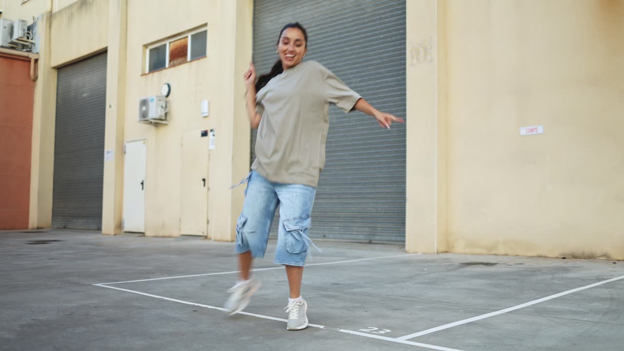 Giovane donna energica che balla hip hop in un ambiente urbano.