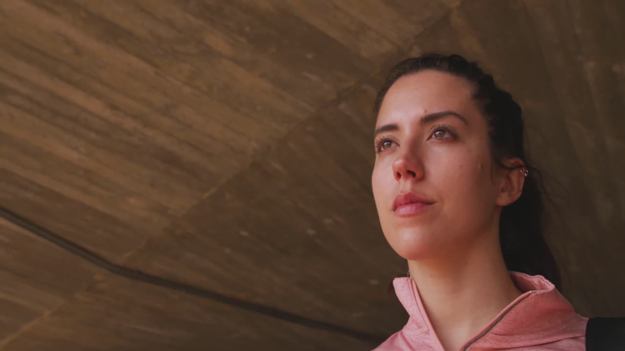 Mujer caucásica caminando debajo de un puente