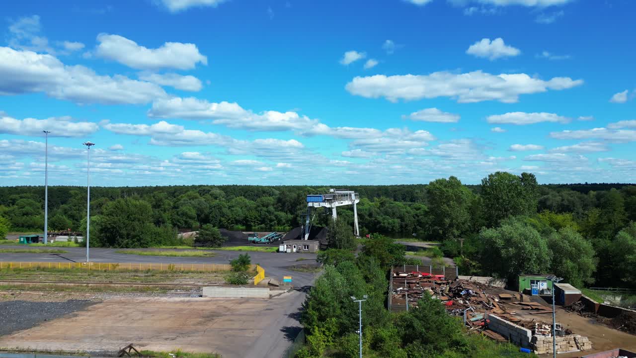 Gantry crane transporting scrap metal at Hennigsdorf electric steel mills on a sunny summer day. Magic aerial view flight descending drone