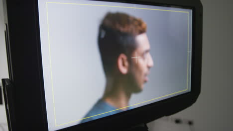 actor masculino ensayando o filmando una película o un video en un estudio de cine visto en el monitor de la cámara