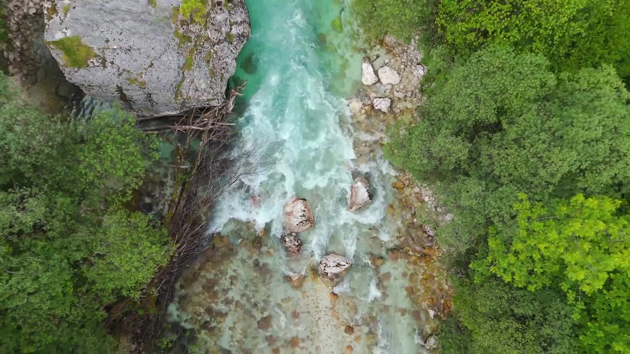 Aerea: fiume Soca turchese che scorre attraverso la Valle di Trenta di giorno in Slovenia, Europa, ripresa drone dall'alto.