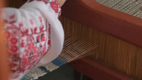 weaver makes fabric in ethnic loom