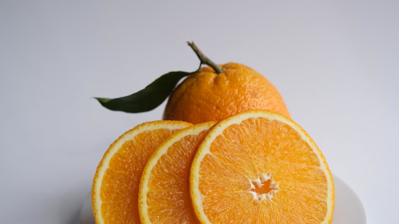 naranja madura y jugosa. naranja recién cortada sobre un fondo de naranja con hojas