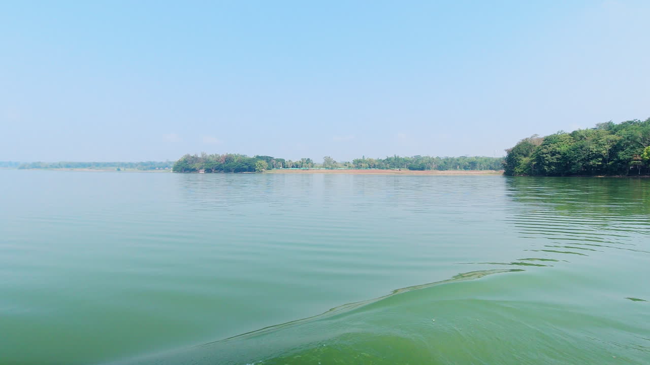 View of Kabini river and Nagarahole forest shoreline during an afternoon boat ride in Karnataka, India. Slow Motion.