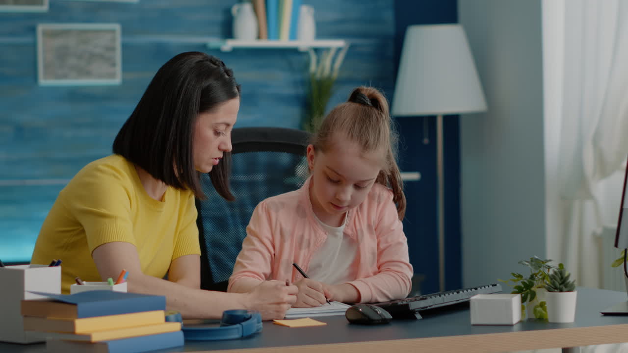 Schoolgirl and parent doing homework together with monitor