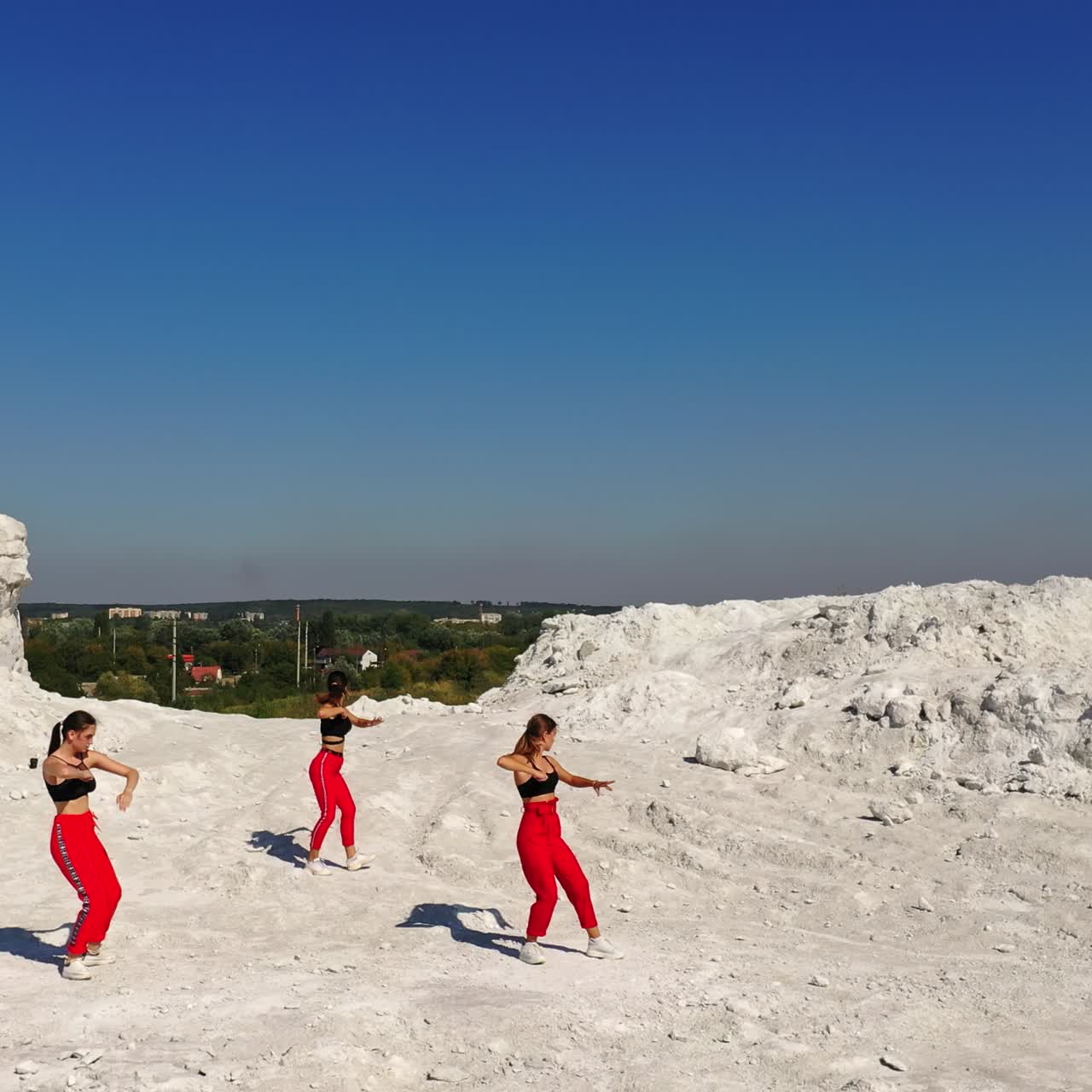 Gruppe af unge kvindelige dansere udendørs. Pigerne optræder med jazz-funk dansestil på klipperne. Top view