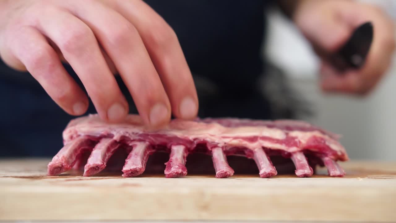 Chef begins trimming fat on rack of lamb