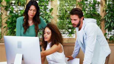 equipo de ejecutivos discutiendo sobre la computadora en el escritorio