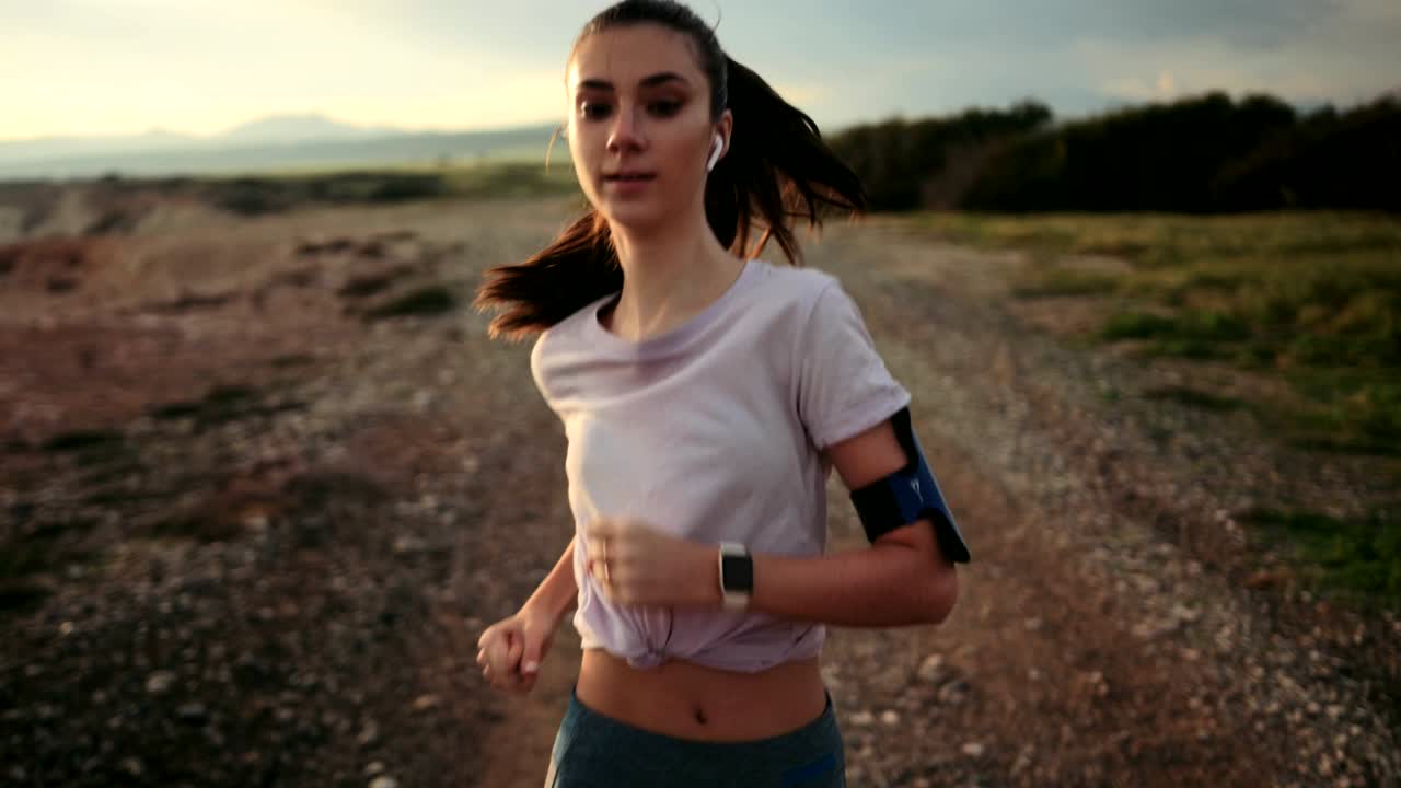 corredora corriendo en un acantilado y escuchando música