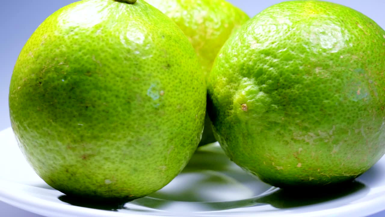 una rebanada de limón verde está girando lentamente en el estudio con los detalles.