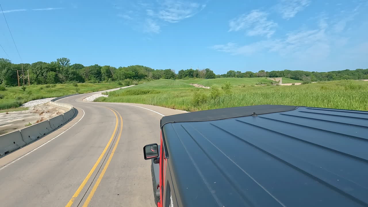 POV from vehicle roof - driving past the spillway for the overflow dam of Saylorville Lake in central Iowa; concepts of flood control