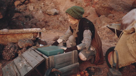 woman taking old record player from box at dystopian campsite