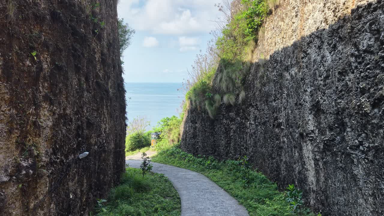 崖の間を抜ける狭い道、パノラマの海の景色が広がる