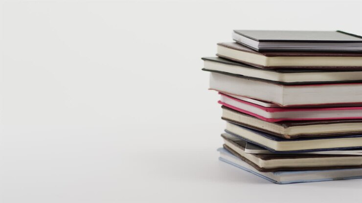 Primo piano di una pila di libri con spazio per il testo su sfondo bianco.