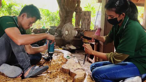 skilled artisans collaboratively carving wood sculpture