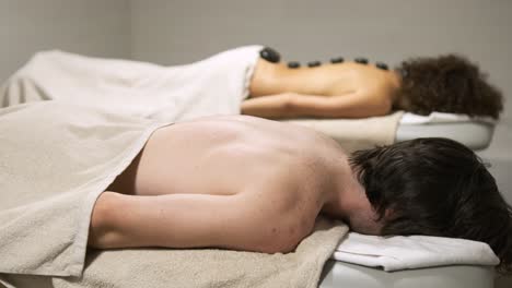 relaxing hot stone back massage being enjoyed by a man in a tranquil setting
