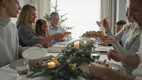 Familia-Caucásica-Sentada-Alrededor-De-La-Mesa-Y-Pasando-La-Navidad-Juntos.