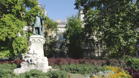 prominente estatua se encuentra dentro de un jardín bien cuidado en budapest, hungría