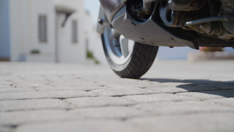 Confident-biker-woman-shoe-raises-side-stand-of-motorbike-in-close-up