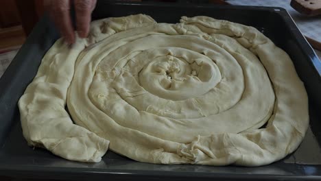 grandmother's wrinkled hands carefully placing pie dough in tray for baking - cherished culinary craft