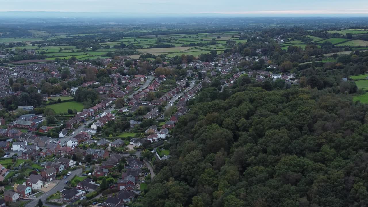 Aerial view above Halton North England coastal countryside town estate green space slow orbiting left