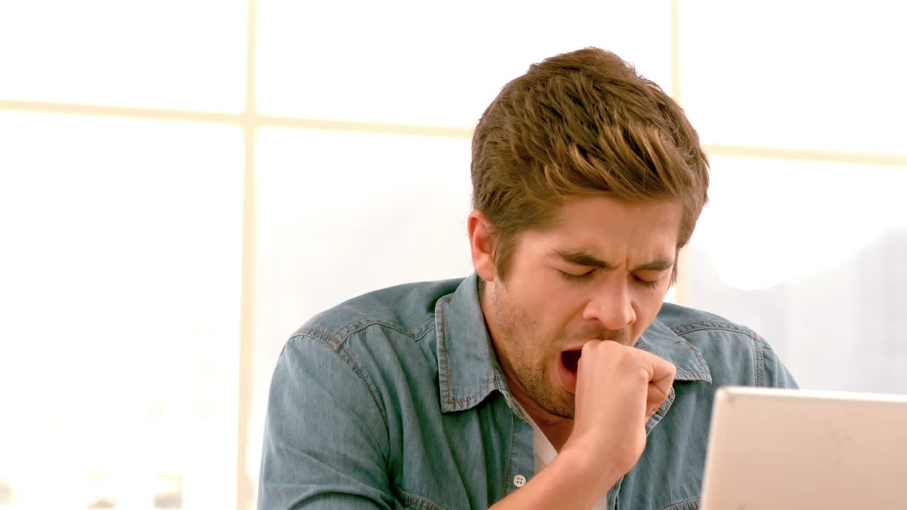 el hombre de negocios creativo cansado bostezando