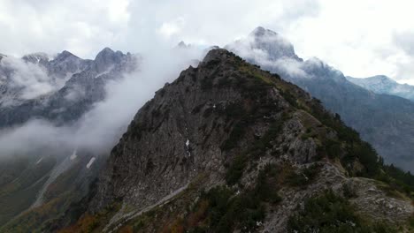 pico alto de la montaña con el fondo de los alpes bajo niebla y nubes en otoño