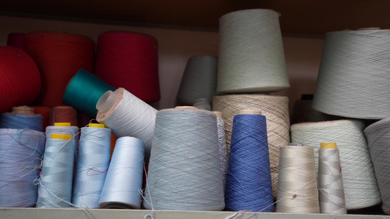 Bunte Nähgarne und lebendige Textilgarne, verwendet zum Stricken verschiedener handgefertigter Modeartikel.