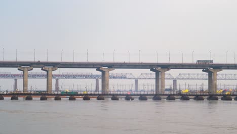 railway and road bridge over ganga or ganges river with train and vehicles passing in prayagraj or allahabad in uttar pradesh india
