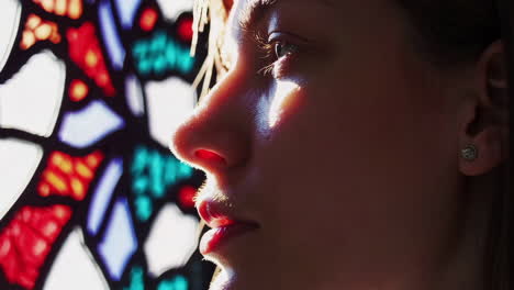 woman gazing through stained glass window