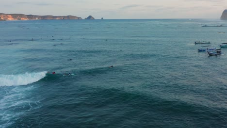 Surfing-at-sunset-at-the-surf-spot-Don-Don-in-Gerupuk,-Lombok