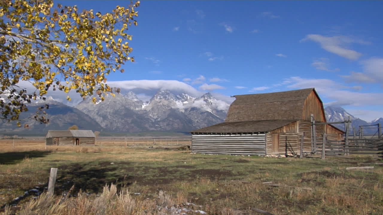 En gammel låve med tilhørende innhegning forfaller sakte nær Grand Teton-fjellene