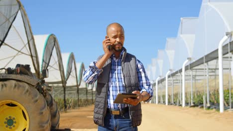 Man-talking-on-mobile-phone-in-blueberry-farm-4k