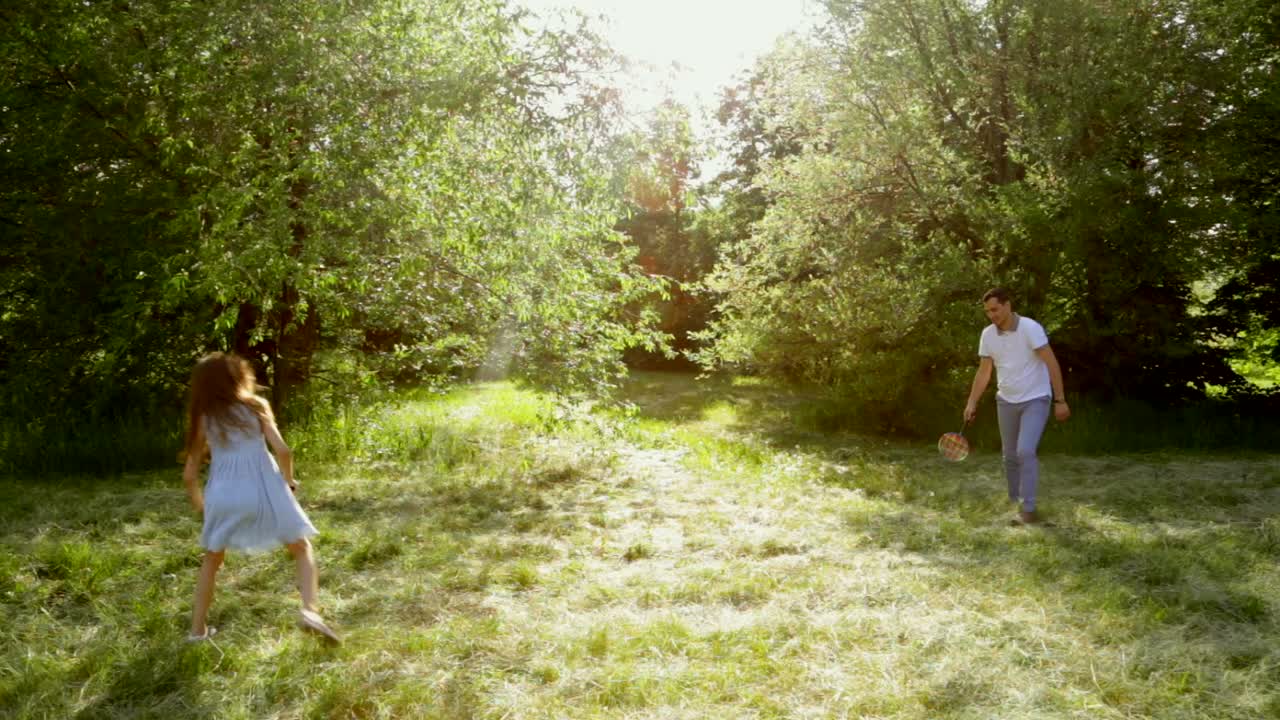 Father and Daughter Playing Badminton in Park