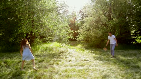 father and daughter playing badminton in park