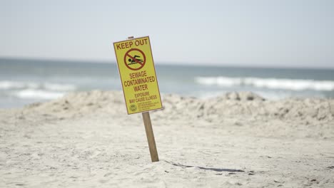 keep out sewage contaminated water beware sign on imperial beach california sunny day - slow motion tight shot