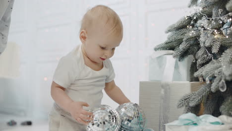 small boy playing mirror balls in living room