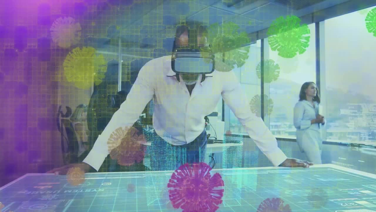 Animation von Covid-Viruszellen über einem Mann mit VR-Headset, der im Büro arbeitet