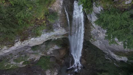 aerial view of a stunning waterfall cascading down a rocky cliff, captured by a drone in the swiss alps near walenstadt