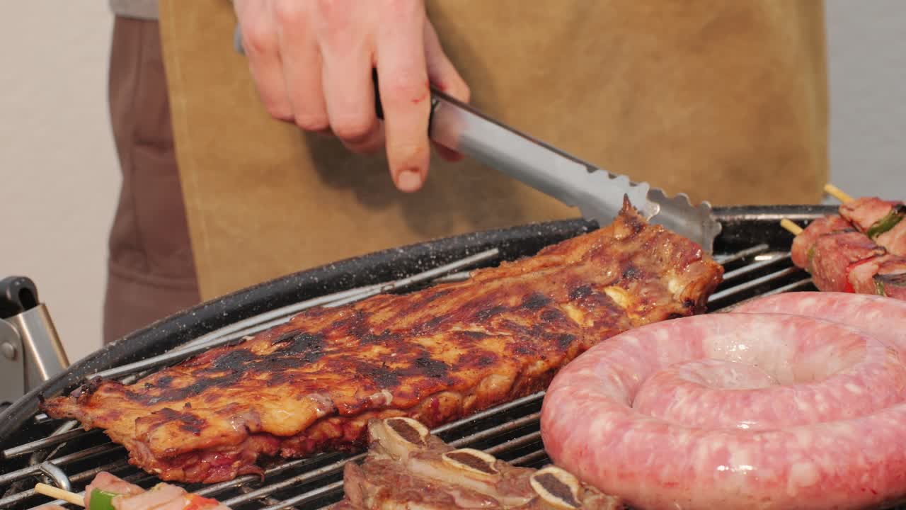 Traditional spanish barbeque, big sausage chorizo botifarra, pork and beef ribs on grill with fire, american style cooking, chef grilling meat fat food, steaks and sausages on bbq. High quality 4k footage