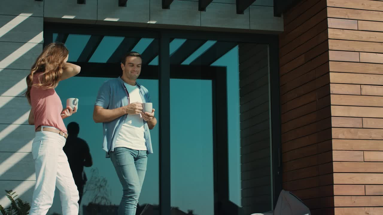 pareja hablando afuera en cámara lenta. hombre y mujer bebiendo café en la terraza.