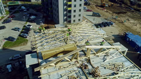 Aerial-ascending-shot-of-industrial-worker-working-on-rooftop-of-block-complex-in-town