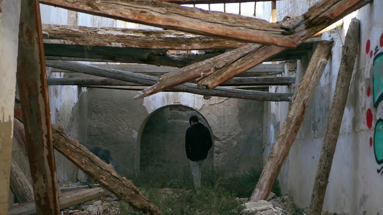 10대 청년이 기둥이 무너진 채 버려진 장소를 걷고 있다