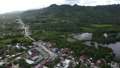 Southeast-Asian-Village-in-Philippines-Anda-Establishing-Tropical-Green-Mountain-View,-Aerial-Drone