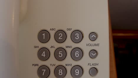 close-up of an old-fashioned telephone keypad as the camera moves slowly from bottom to top. retro communication technology detail showing numeric and function buttons