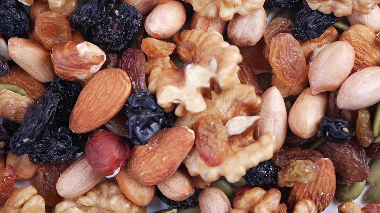 Slow Motion Close-Up of Nuts and Dried Fruits Falling and Mixing