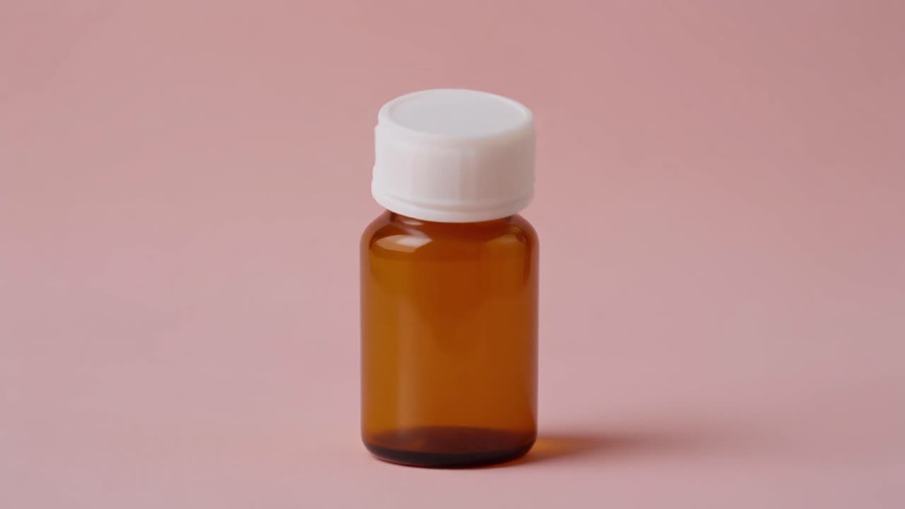 Botella de vidrio ámbar con tapa blanca siendo desenroscada sobre fondo rosa
