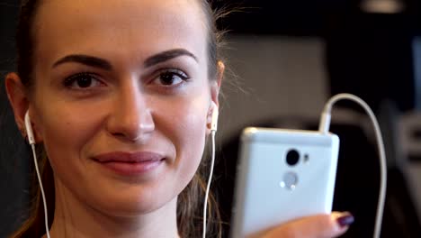 primer plano de una cara de chica sonriente que cambia algo en el teléfono