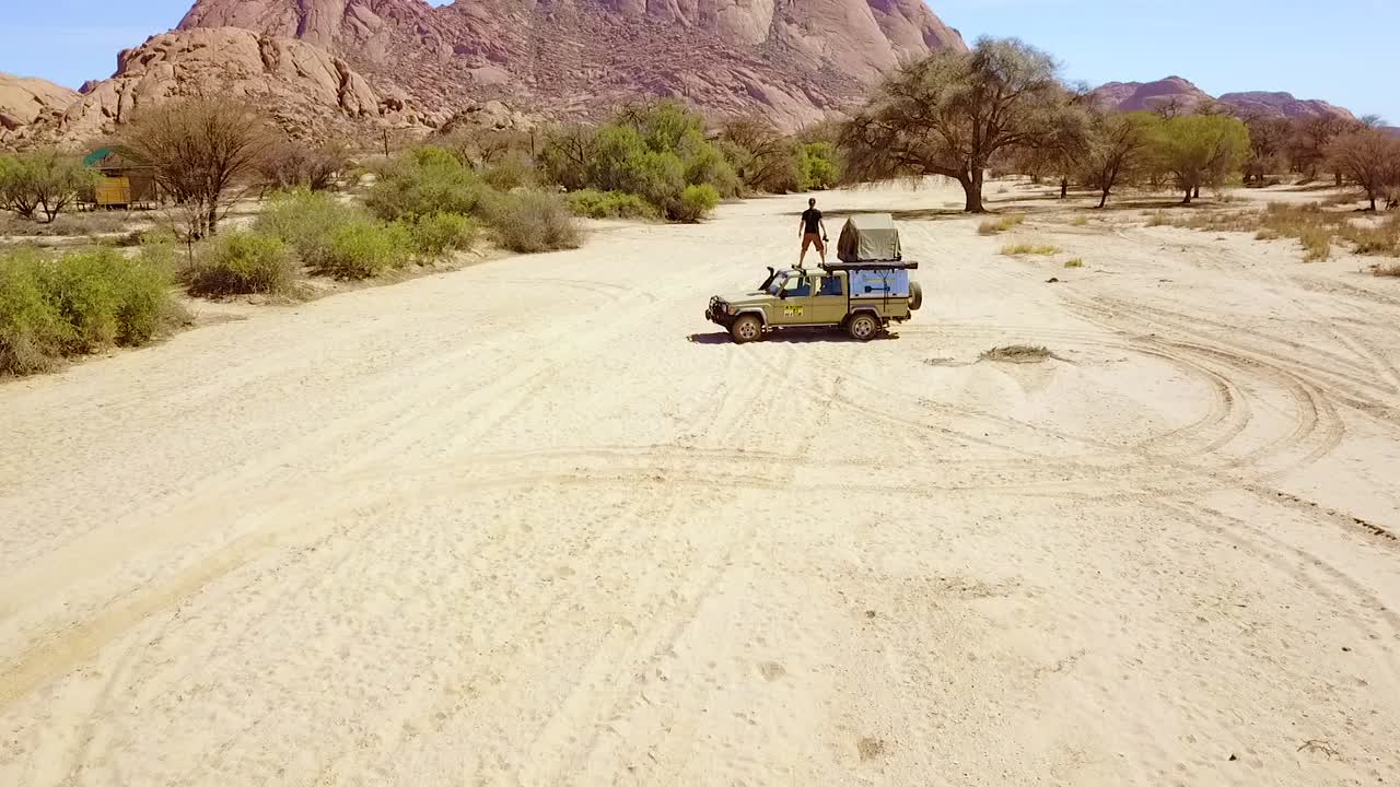 spitzkoppe namibia africa에서 암석 사진을 찍는 4wd 사파리 캠퍼 밴에 서있는 남자 위에 공중