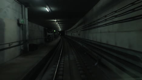 cabin view of train moving in dark subway tunnel